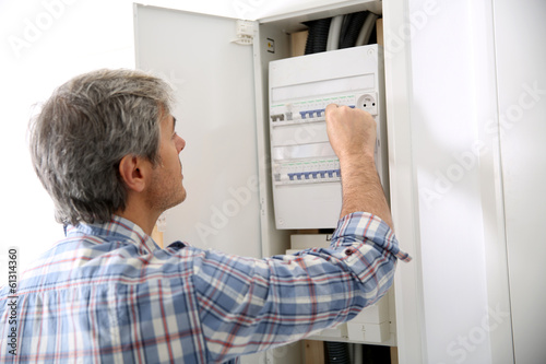 Technician checking on electric box in private home photo