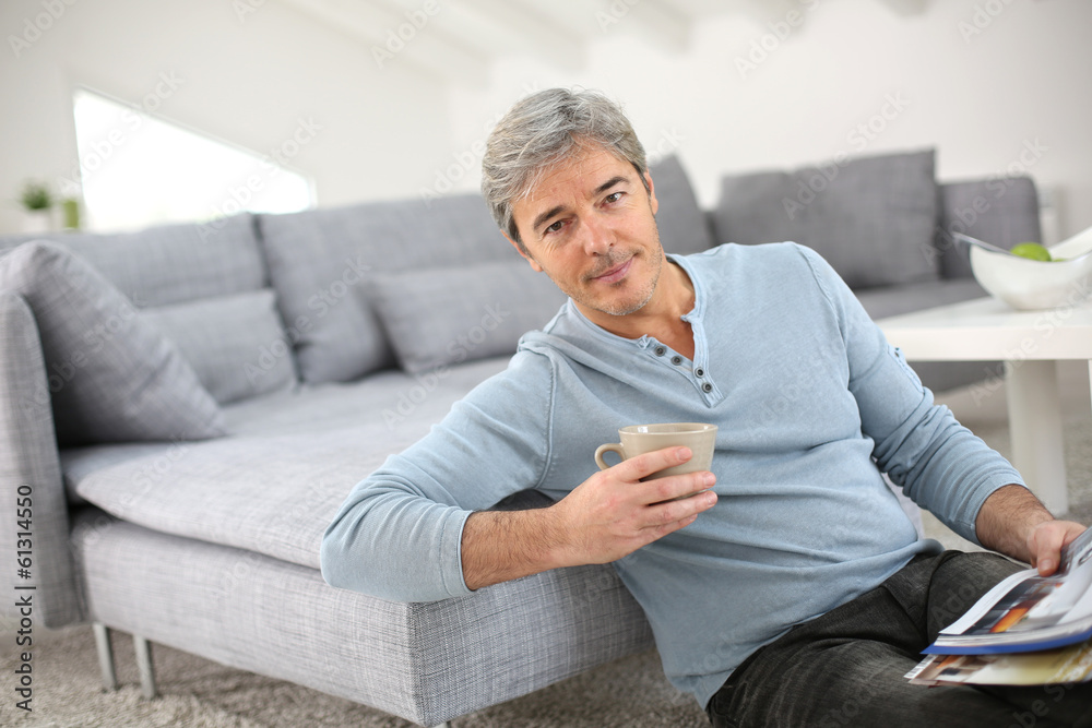 Senior relaxing at home and reading magazine Senior relaxing at home and reading magazine
