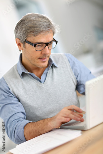 Senior businessman in office working on laptop