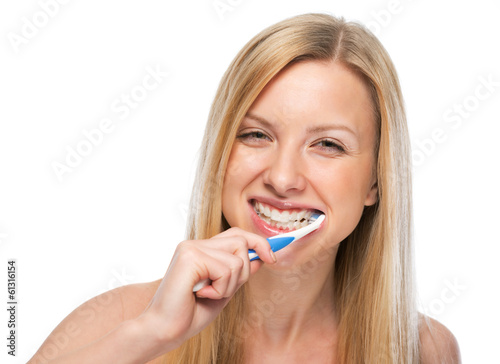 Smiling young woman brushing teeth