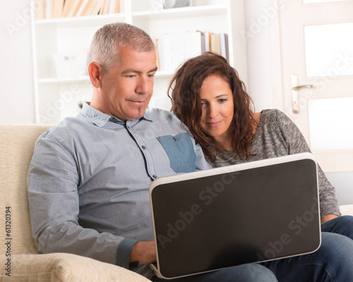 Couple using laptop at home © Monika Wisniewska