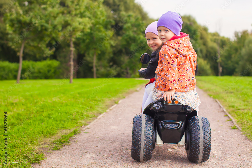 Portrait of little girls ride a motorbike outdoors Portrait of little girls ride a motorbike outdoors