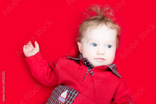Adorable little baby on a red blanket