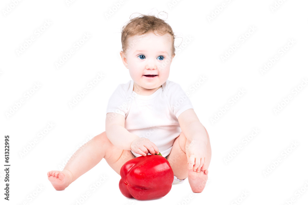 Little baby playing with a big red paprika, isolated on white Little baby playing with a big red paprika, isolated on white