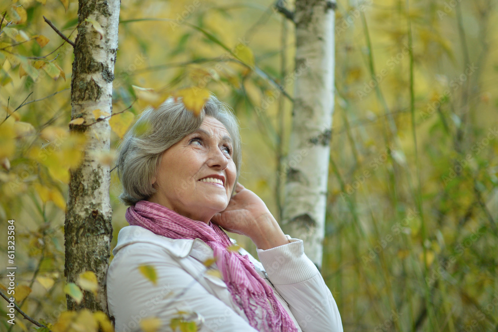 Elderly woman in birch forest Elderly woman in birch forest