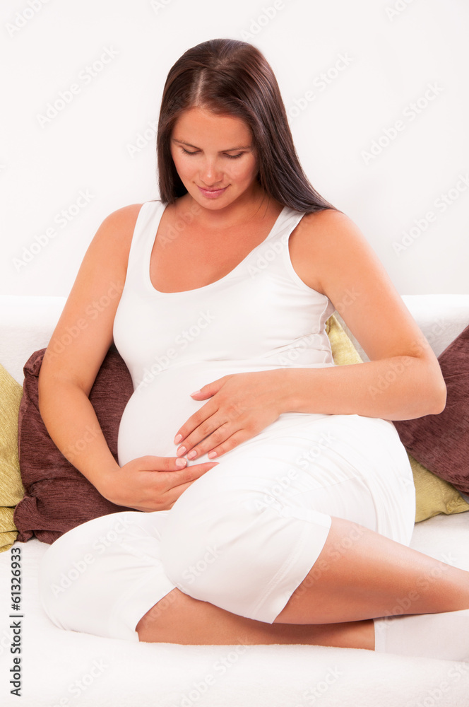 Pregnant woman relaxing at home on the couch Pregnant woman relaxing at home on the couch