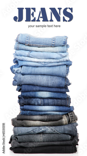 Many jeans stacked in a pile isolated on white photo