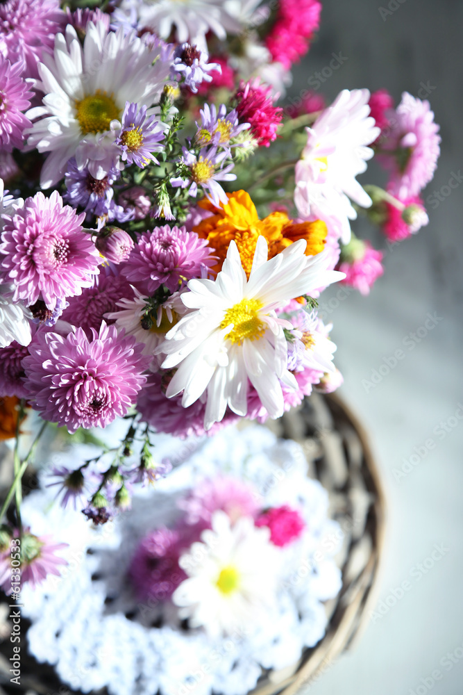 Wildflowers in glass vase on wicker tray close-up Wildflowers in glass vase on wicker tray close-up