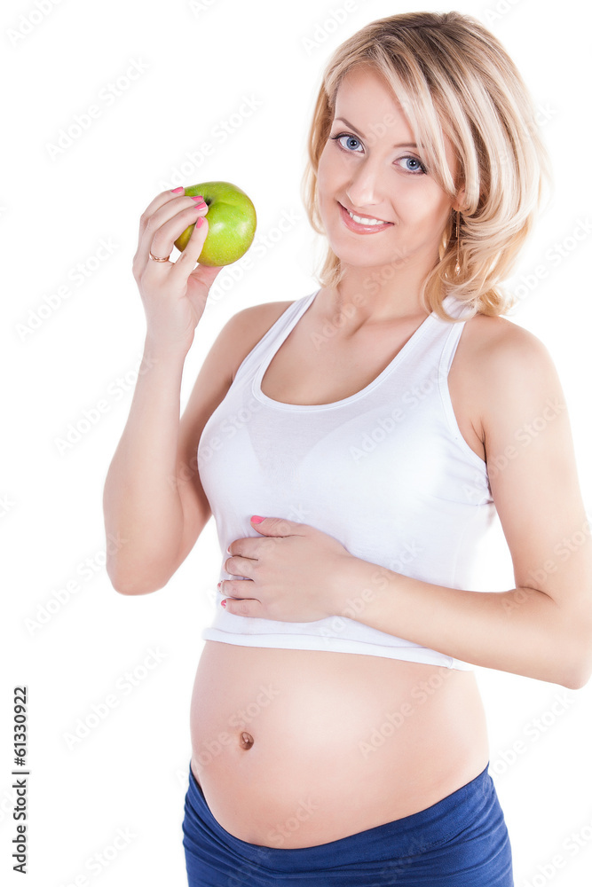 A pretty pregnant woman holding green apple while isolated A pretty pregnant woman holding green apple while isolated