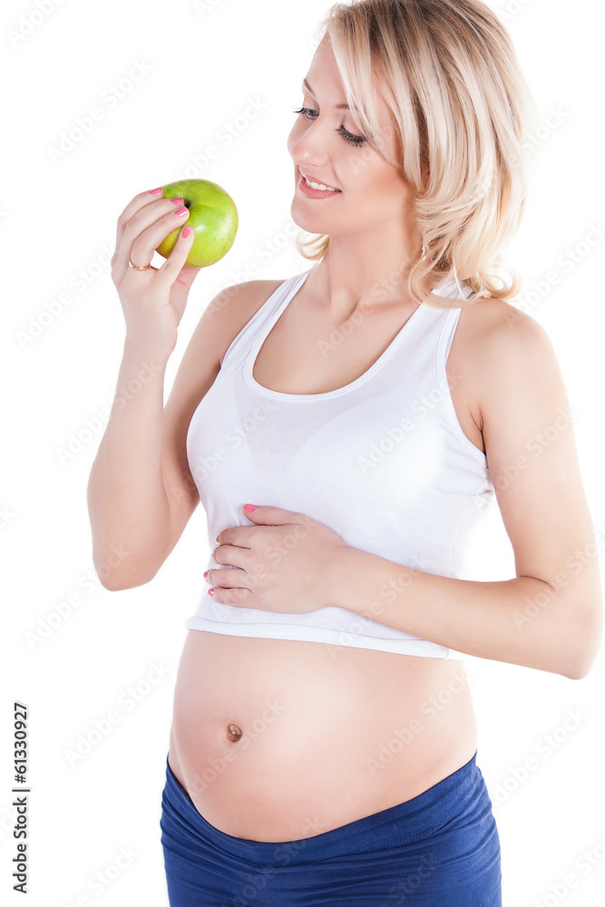 A pretty pregnant woman holding green apple while isolated A pretty pregnant woman holding green apple while isolated