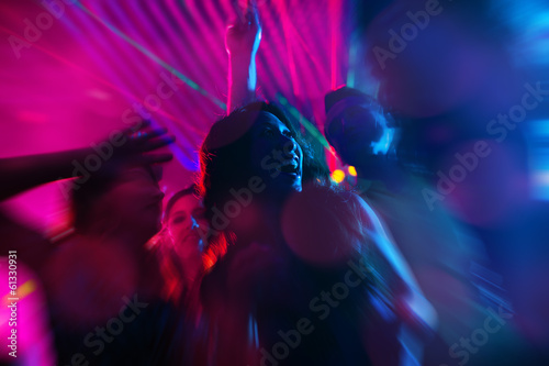 Party people dancing in disco or night club