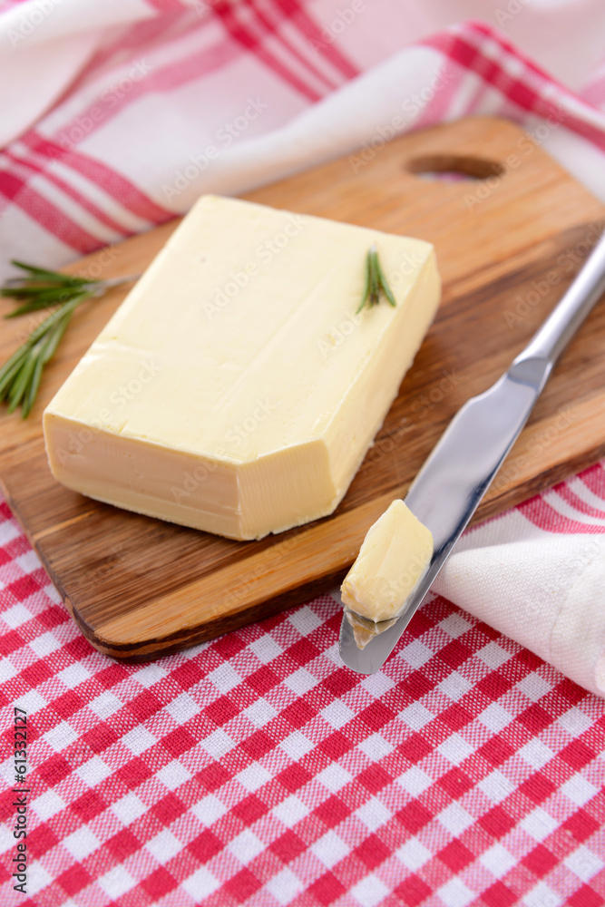 Tasty butter on wooden cutting board