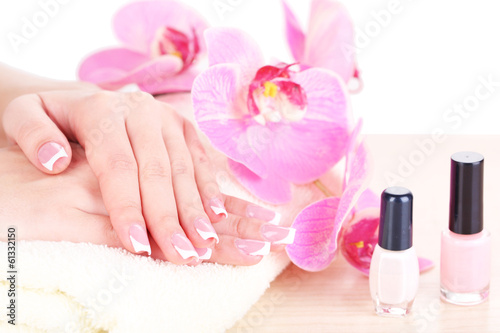 Beautiful woman hands with french manicure and flowers