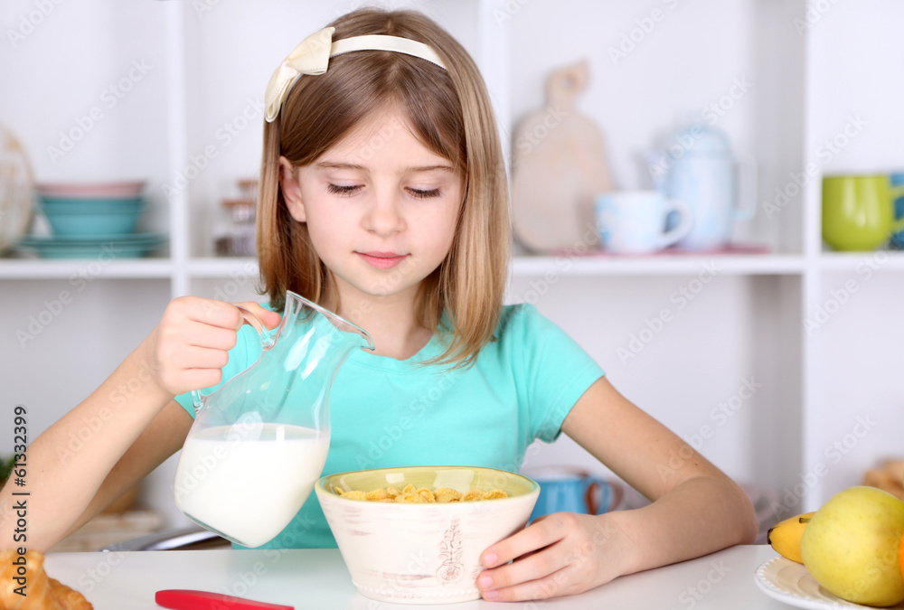Beautiful little girl eating breakfast in kitchen at home Beautiful little girl eating breakfast in kitchen at home