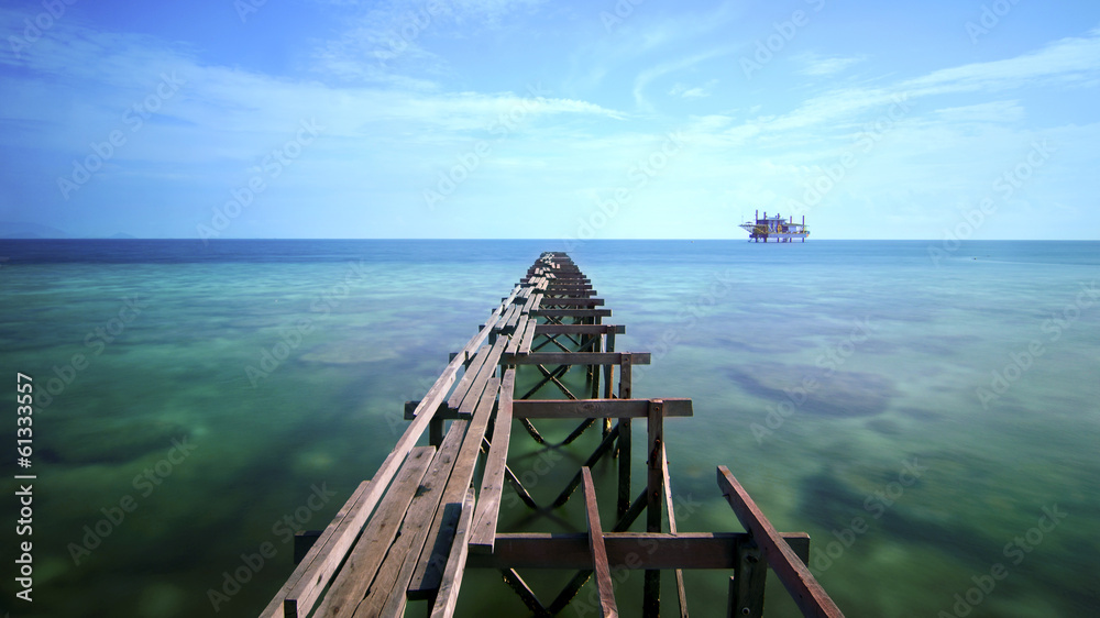 view of old broken jetty during sunny day with coral and green s