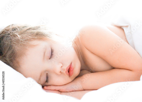 Cute baby girl is sleeping on white bed