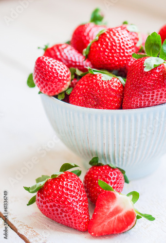 Closeup of strawberries in a bowl on wooden backgorund