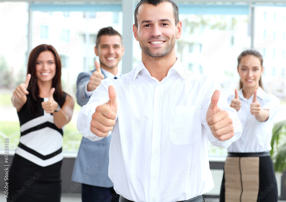 attractive businessman with team in office showing thumbs up attractive businessman with team in office showing thumbs up