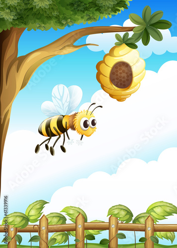 A tree near the fence with a beehive and a bee