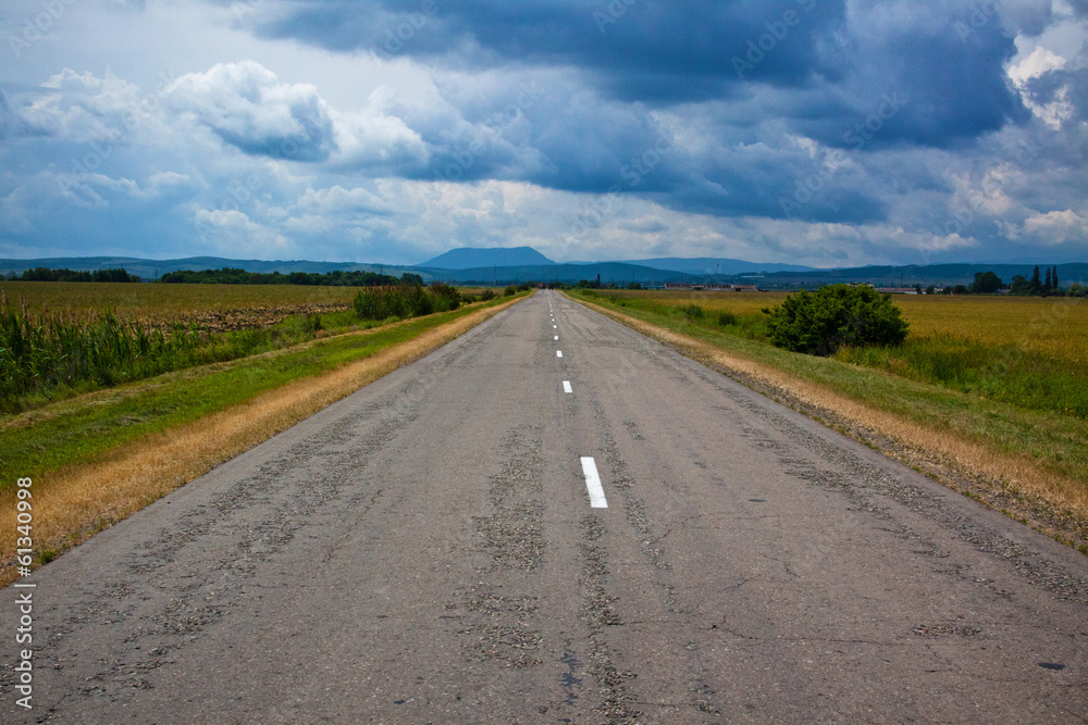 Country road and foothills on a background