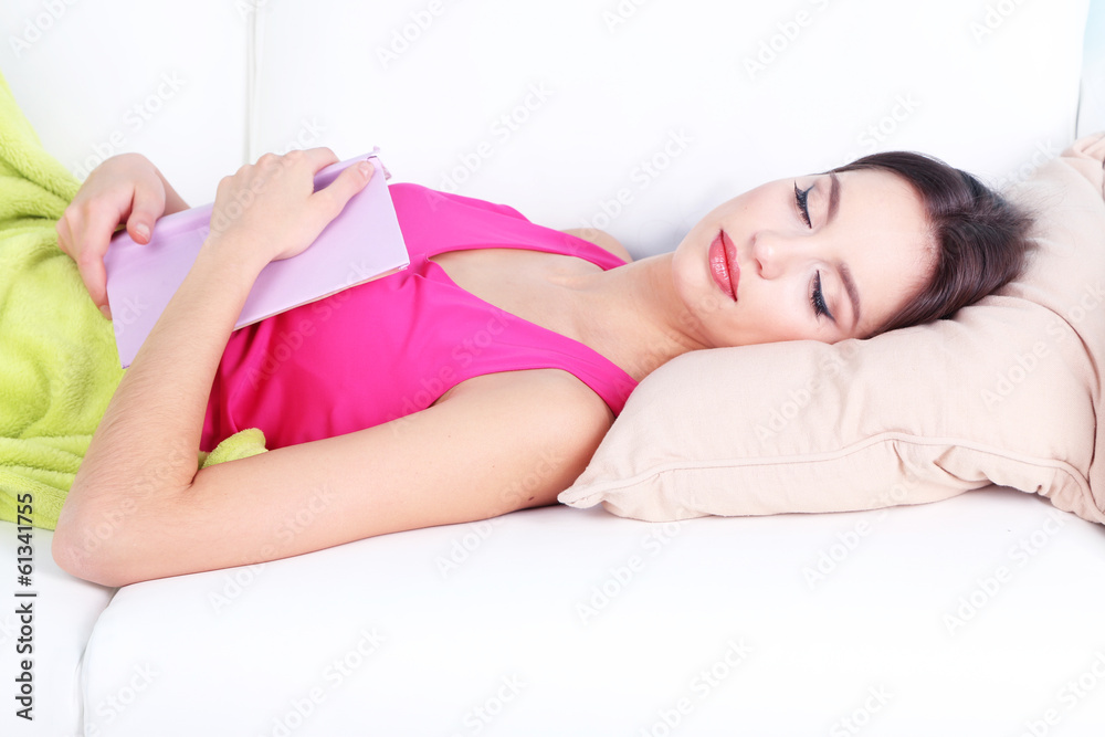 Beautiful young woman sleeping with book on sofa close up Beautiful young woman sleeping with book on sofa close up