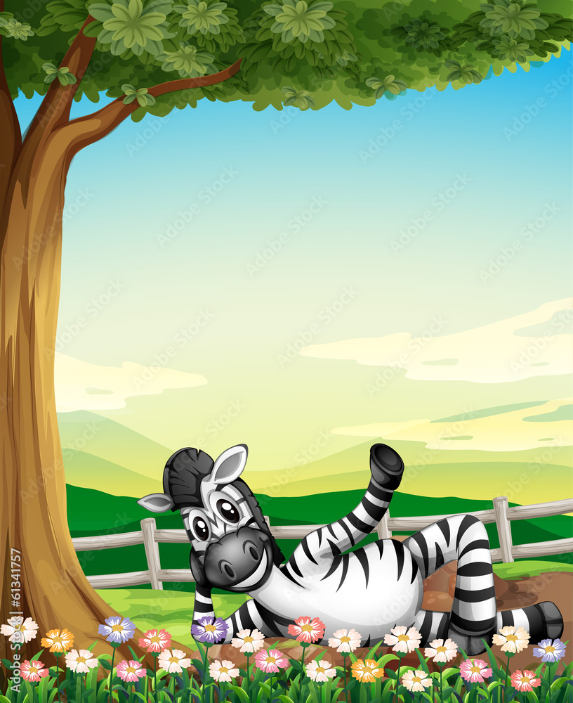 A smiling zebra under the tree near the flowers