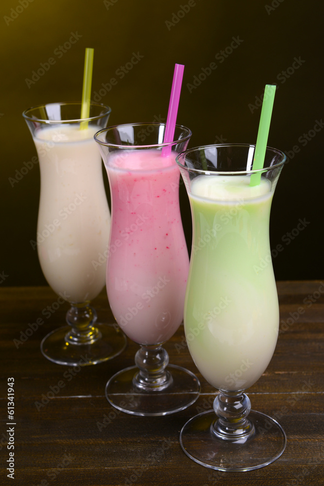 Milk shakes on table on dark yellow background Milk shakes on table on dark yellow background