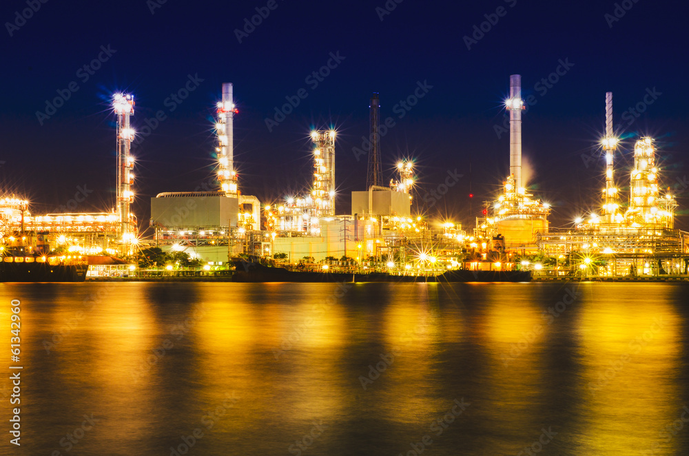 Oil and gas refinery at twilight with reflection