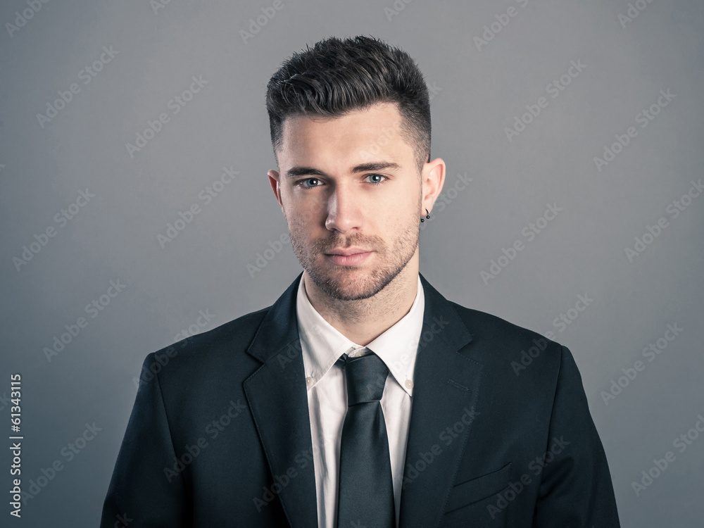 Young businessman portrait against dark background. Young businessman portrait against dark background.