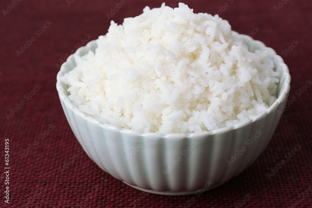 Cooked rice in bowl on red background Cooked rice in bowl on red background