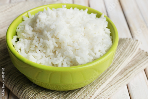 Cooked rice in bowl on wooden background