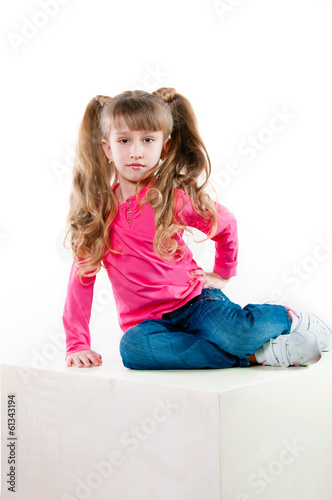 Little girl with long curly hair in a pink blouse