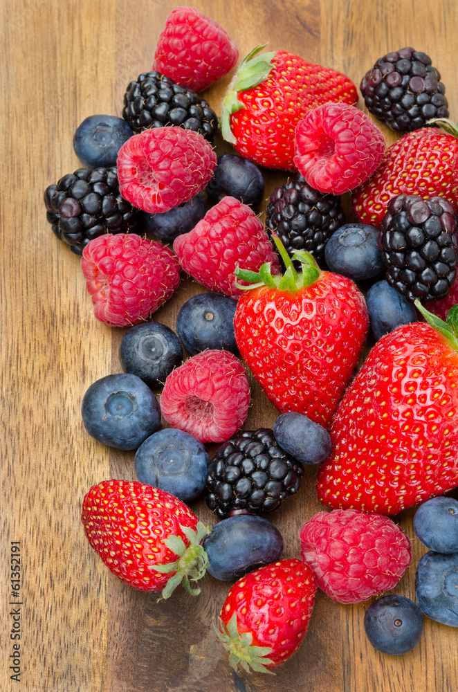 assorted fresh berries on wooden background