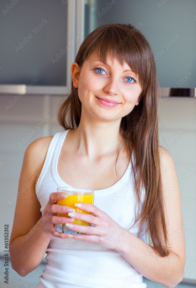 Young brunette girl with a glass of juice in the kitchen Young brunette girl with a glass of juice in the kitchen