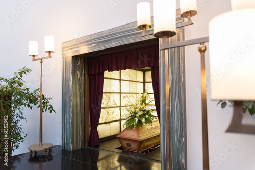 Wooden coffin with funeral flowers in crematorium photo