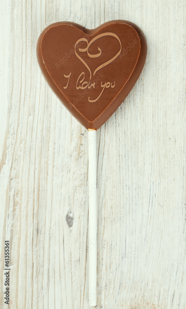heart-shaped chocolate candy on wooden surface heart-shaped chocolate candy on wooden surface