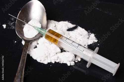 Drug syringe and cooked heroin on spoon photo