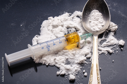 Drug syringe and cooked heroin on spoon