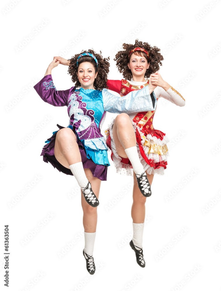 Two young women in irish dance dress dancing isolated Two young women in irish dance dress dancing isolated