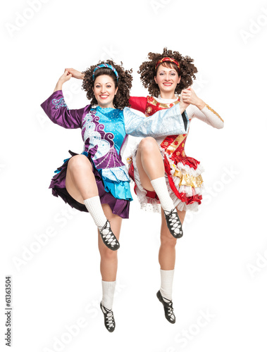 Two young women in irish dance dress dancing isolated