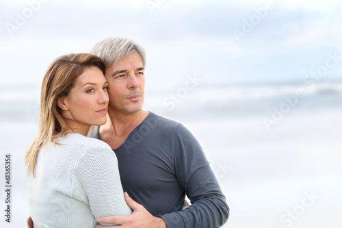 Cheerful middle-aged couple looking to the ocean