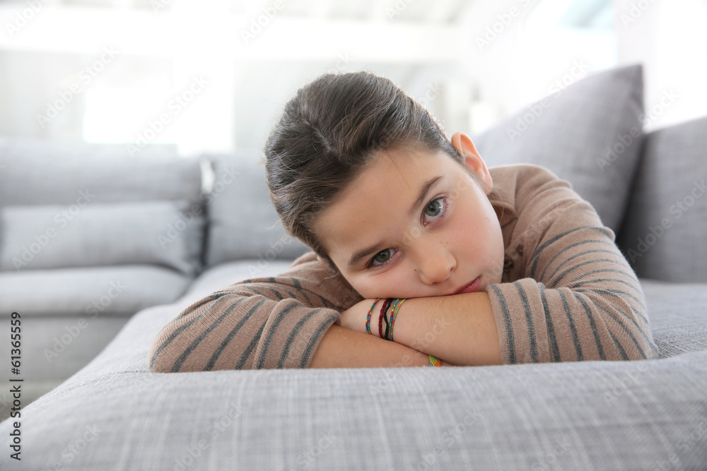 Portrait of sad little girl laying on couch Portrait of sad little girl laying on couch