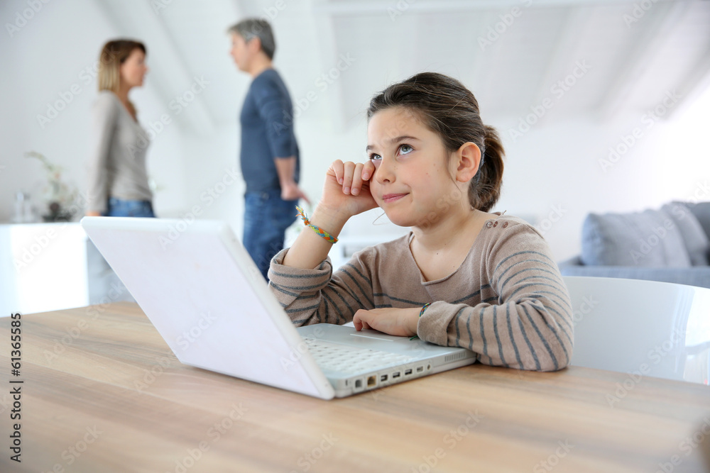 Young girl at home trying to do homework on laptop Young girl at home trying to do homework on laptop