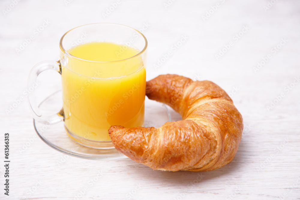 Orange juice in a glass cup and a french bun Orange juice in a glass cup and a french bun