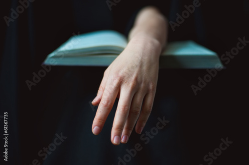 Hand lying on open book