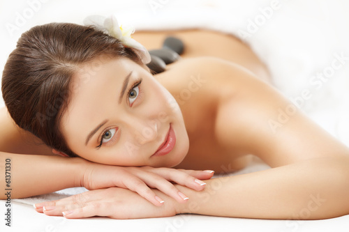 Beautiful Woman Getting Hot Stone Massage in Spa Salon. 