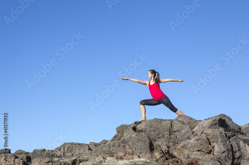 Young woman practicing yoga warrior pose outdoor