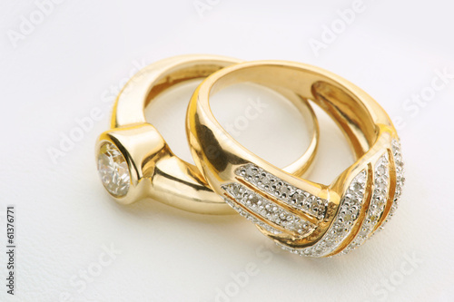 Jewelry Elegant Gold wedding or engagement rings with diamond on white background close up photo