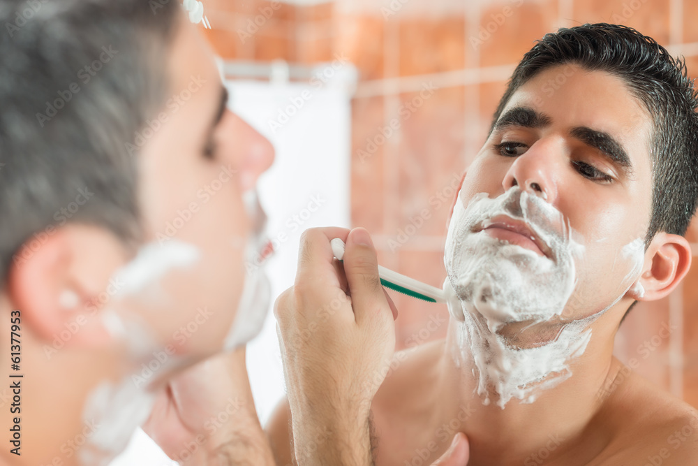 Young hispanic man shaving