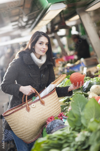 young woman choosing vegetables on a market photo